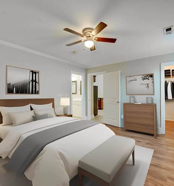 A bedroom with a large bed and a ceiling fan.