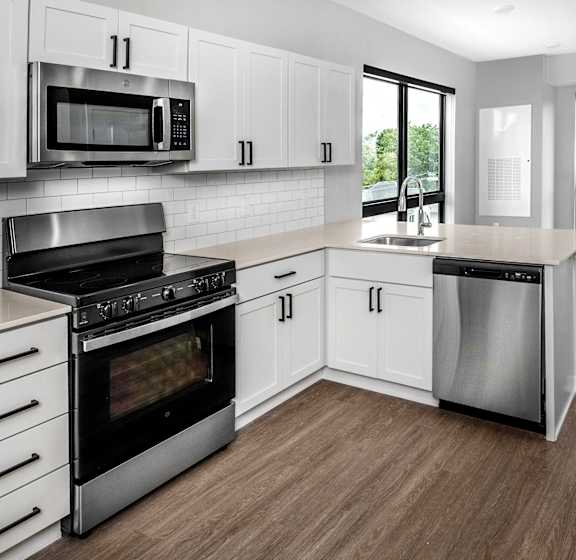 a white kitchen with stainless steel appliances and white cabinets