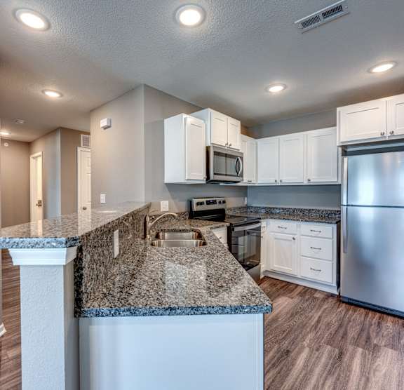 A kitchen with granite countertops and stainless steel appliances.