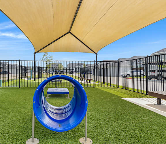 A playground with a blue slide and a yellow canopy.