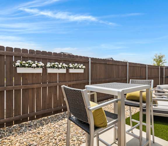 A backyard with a table and chairs.