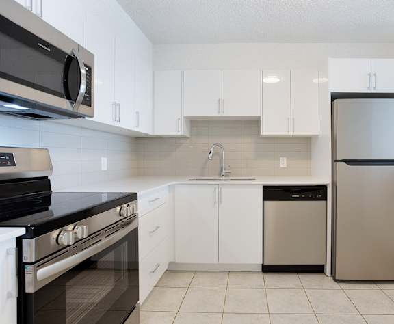 A kitchen with white cabinets and a black stove top oven.