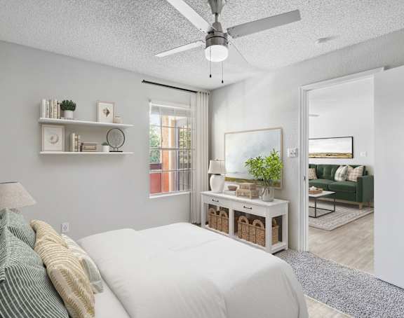 A bedroom with a bed, a ceiling fan, and a window.