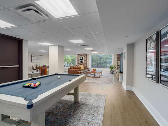 A modern living room with a large abstract painting on the wall and a wooden floor.