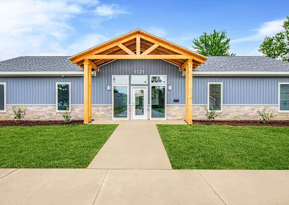 A building with a wooden front entrance and a glass door at Poplar Place Apartments, Illinois