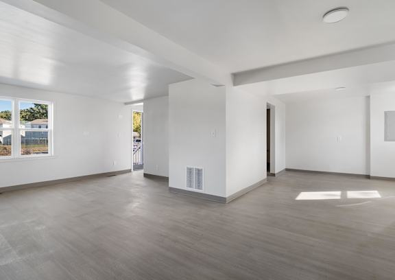 A spacious room with white walls and a wooden floor at Poplar Place Apartments, Springfield