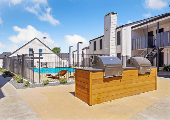 a patio with a grill and a swimming pool