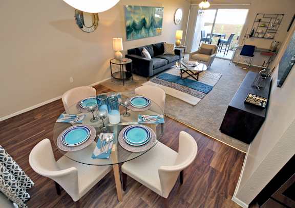 a dining room table with plates and chairs and a living room with a couch