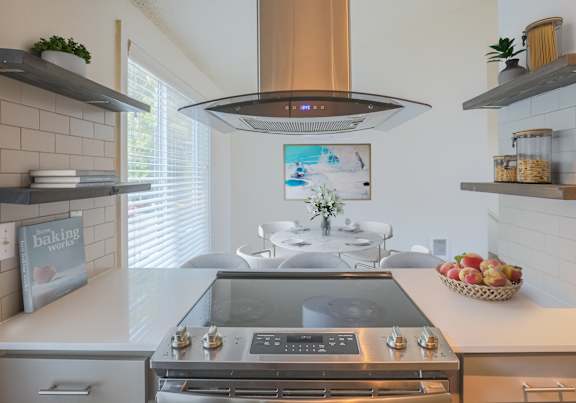 A modern kitchen with a stainless steel range hood above the stove.
