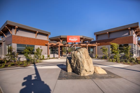 a large rock sits in front of a building with a sign