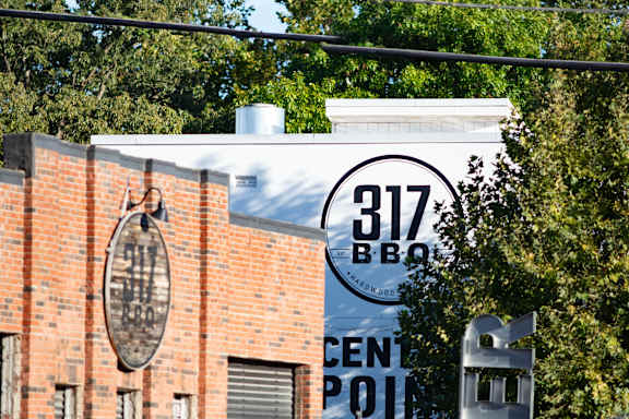 A brick building with a sign that says 317 BBQ.