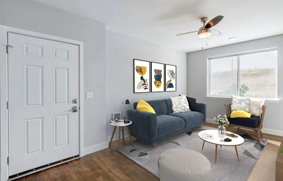 A living room with a grey couch, a white table, and a white door.