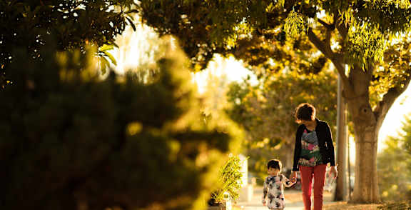 a mother and child walking down a sidewalk