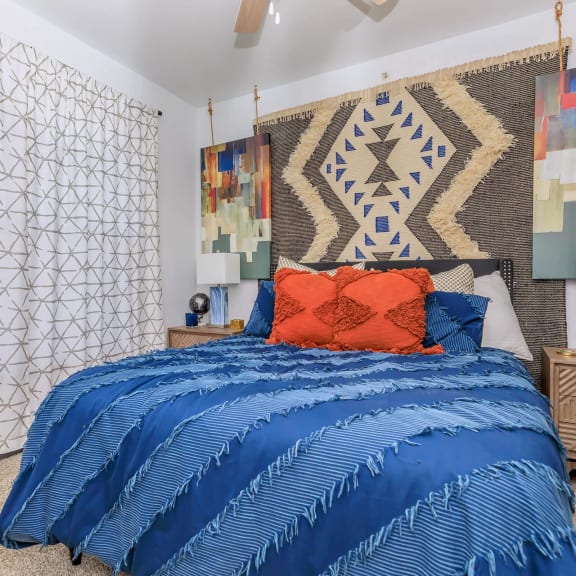 a bedroom with a bed and a tapestry on the wall