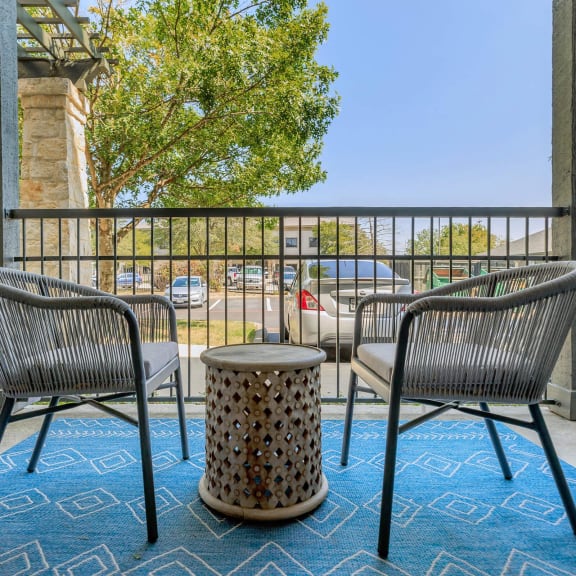 a patio with chairs and a table on a balcony