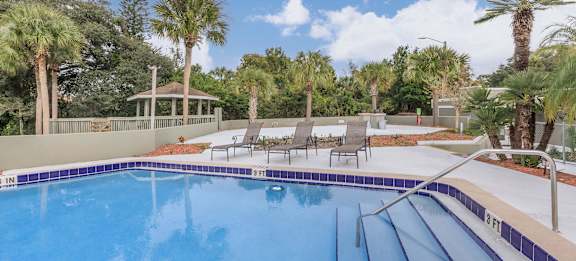 a swimming pool at a resort with palm trees