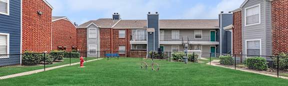 A grassy area in front of apartment buildings.