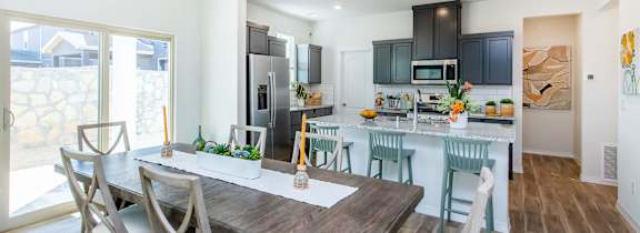 A modern kitchen with a dining table and chairs.