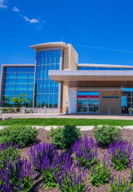 a building with purple flowers in front of it at The Residences at Bluhawk Apartment Homes, Overland Park, KS