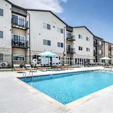 A swimming pool in front of apartment buildings.