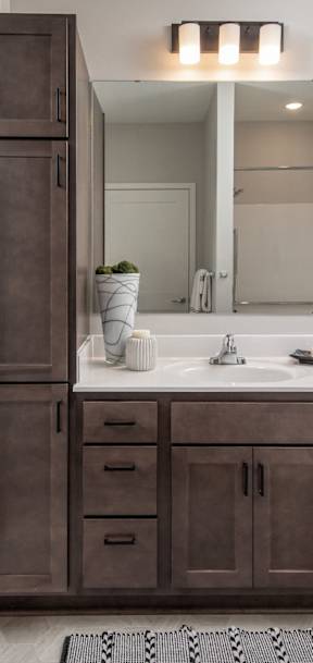 A bathroom with a brown cabinet and white walls.