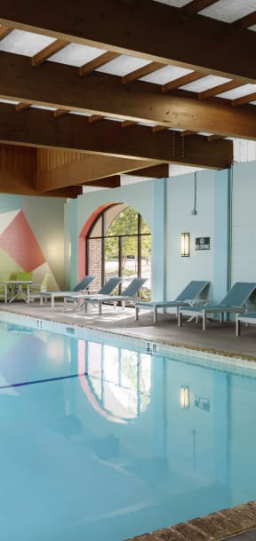 a swimming pool with chairs and a reflection of the water in it  at Pebblebrook Court, Minnesota