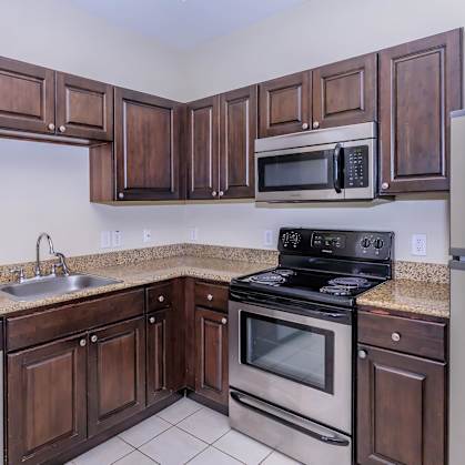 A kitchen with dark wood cabinets and stainless steel appliances.