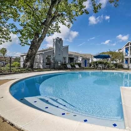A swimming pool surrounded by a wooden deck and a fence.