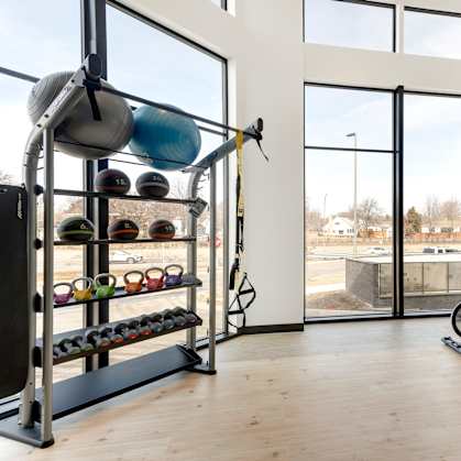 A gym with a row of exercise bikes and a rack of kettlebells. at Zelia on Seven, Minnesota, 55416