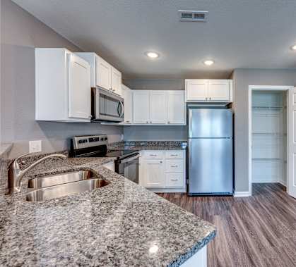 A kitchen with granite countertops and stainless steel appliances.