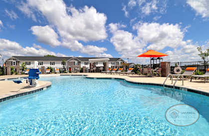 our apartments have a large swimming pool with chairs and an umbrella