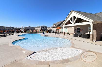 A swimming pool with a fountain in the middle of it.