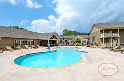 A swimming pool in a resort with a mountain in the background.
