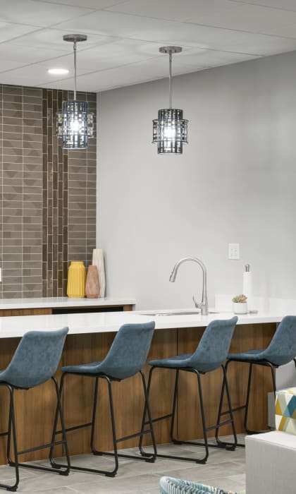 a kitchen with a bar and chairs and a refrigerator at Hamline Terrace, Roseville, MN, 55113