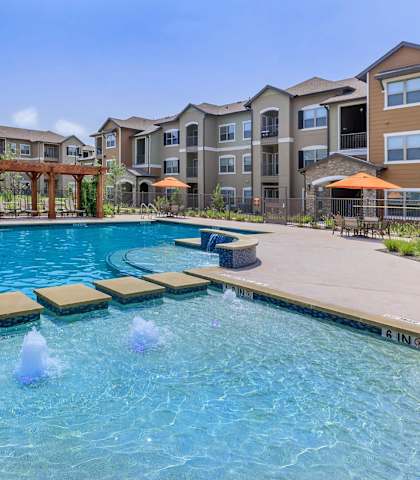 a large swimming pool with apartments in the backgroundat Cypress Creek at Hazelwood Street, Princeton Texas