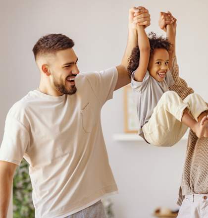 A family of three is playing together in a room.