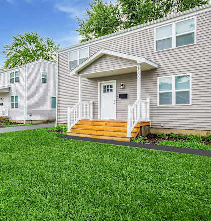 A row of houses with green lawns in front. at Poplar Place Apartments, Springfield, IL