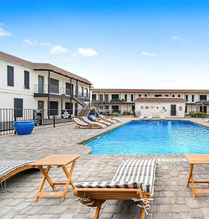 a swimming pool at a hotel with lounge chairs