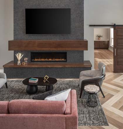 A living room with a fireplace and a television above it.
