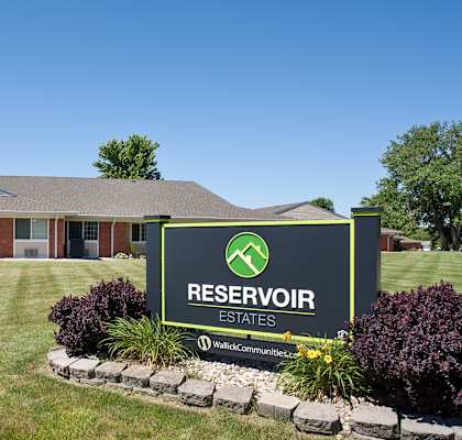 A sign for Reservoir Estates in front of a building.