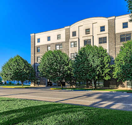 A large building with a lot of windows and trees in front.