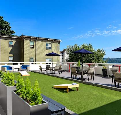 A patio with a table and chairs overlooking a body of water.