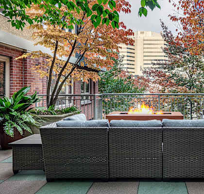 A patio with a fire pit and a couch.