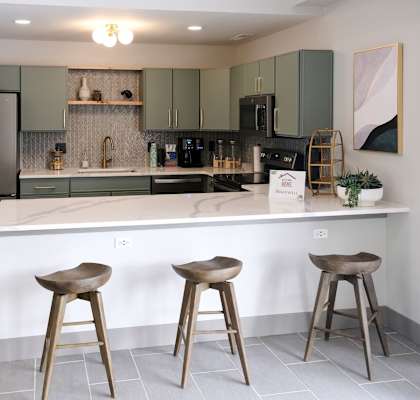 a kitchen with a large island with two stools in front of it