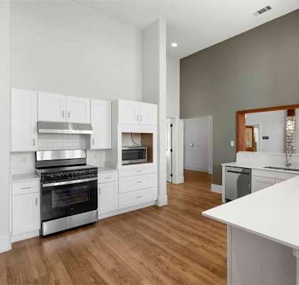 A modern kitchen with white cabinets and stainless steel appliances.