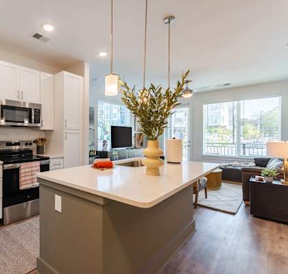 A kitchen with white cabinets and a large island.