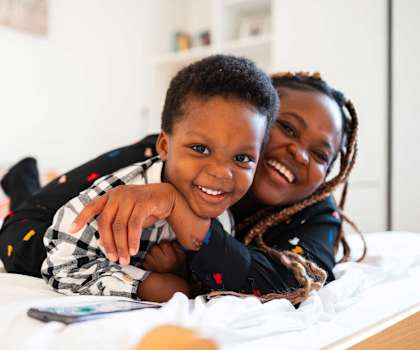 a woman and a child laying on a bed