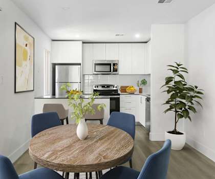 A modern kitchen with a dining table and chairs.