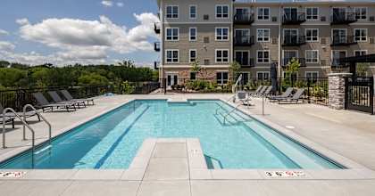 a swimming pool with an apartment building in the background