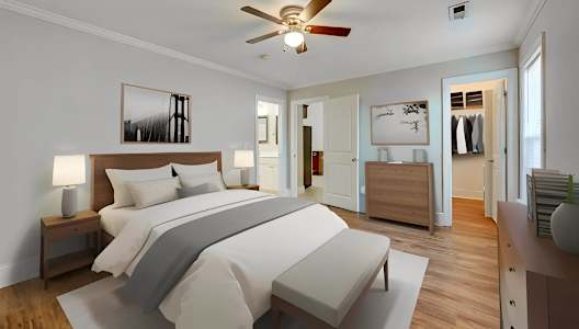 A bedroom with a large bed and a ceiling fan.